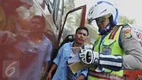 Seorang petugas saat memeriksa kelengkapan surat pengendara di Terminal Kp. Rambutan, Jakarta (6/10/15). Pemeriksaan tersebut untuk menghidari angka kecelakaan dan mengurangi polusi. (Liputan6.com/Gempur M Surya)