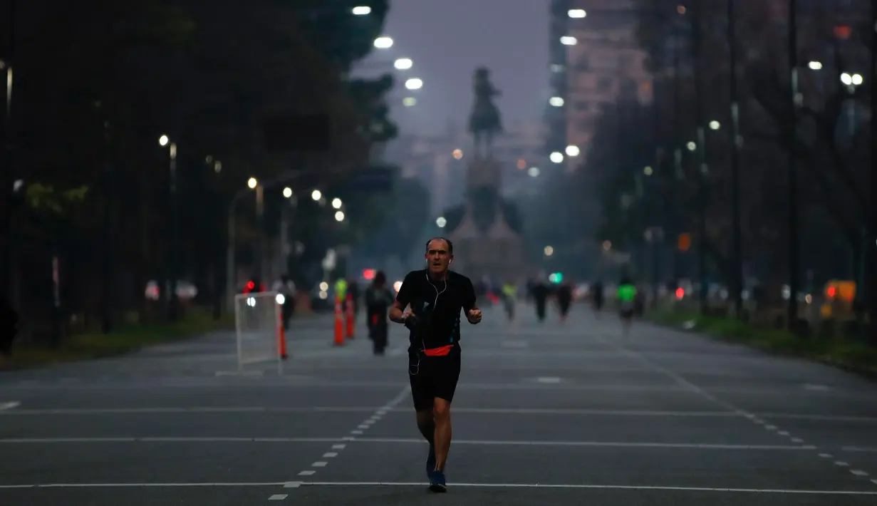 Seorang pria berjogging saat pembukaan kembali area Buenos Aires di Argentina, Senin (20/7/2020). Pembukaan kembali area Buenos Aires, tempat 90% kasus covid-19 ditemukan di Argentina, terjadi saat negara itu melaporkan lebih dari 3 ribu kasus per hari. (AP Photo/Natacha Pisarenko)