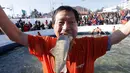Seorang peserta berpose dengan ikan dengan saat acara Festival Es di sungai Hwacheon yang membeku di Korea Selatan, Sabtu (14/1). (AP Photo/Ahn Young-joon)