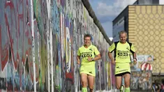 Martina Schliep (kiri) dan Gaston Pruefer berlari di sisi timur Tembok Berlin, Jerman, (11/8/2014). (AFP PHOTO/Tobias Schwarz)