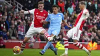 Pemain Manchester City Rodrigo (tengah) menendang untuk mencetak gol melewati pemain Arsenal Rob Holding (kiri) dan Ben White pada pertandingan sepak bola Liga Inggris di Stadion Emirates, London, Inggris, 1 Januari 2022. Manchester City menang 2-1. (AP Photo/Matt Dunham)