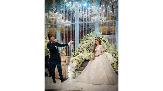 Di atas pelaminan, Guntur bernyanyi khusus untuk Apristiyah yang bahagia mendengarnya.