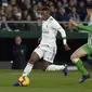 Vinicius jr mencoba melewati hadangan pemain Real Betis pada laga lanjutan La Liga Spanyol yang berlangsung di stadion Benito Villamarin, Senin (14/1). Real Madrid menang 2-1 atas Real Betis. (AFP/Cristina Quicler)