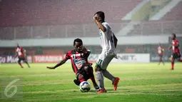 Pemain Persipura Ferinando Pahabol (bawah) berusaha mengambil bola dari pemain Surabaya United, M.Faturahman saat laga 8 besar Piala Jenderal Sudirman di Stadion Maguwoharjo, Sleman, Selasa (22/12/2015). Persipura menang 2-0. (Foto: Boy Harjanto)