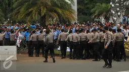 Petugas berusaha menenangkan sopir taksi yang melempar batu saat saat demo di depan Istana Negara, Jakarta, Selasa (22/3). Aksi lempar batu itu pecah saat pengunjuk rasa mendapat ejekan dari pengemudi ojek online. (Liputan6.com/Gempur M Surya)