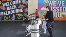 Perempuan dengan mengenakan masker mendorong kereta bayi di Melbourne, Australia, Rabu (28/10/2020). Restoran-restoran dan kafe di Melbourne diizinkan untuk dibuka lagi setelah pemberlakuan lockdown yang ketat selama lebih dari tiga bulan akibat Covid-19.  (AP Photo/Asanka Brendon Ratnayake)