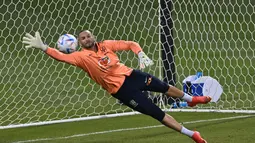 Kiper Brasil, Weverton berusaha menghalau bola saat mengambil bagian dalam sesi latihan di Stadion Al Arabi SC di Doha (6/12/2022). Brasil akan bertanding melawan Kroasia pada babak perempatfinal Piala Dunia 2022 Qatar di Education City Stadium, Doha pada Jumat (9/12) pukul 22.00 WIB mendatang. (AFP/Nelson Almedia)