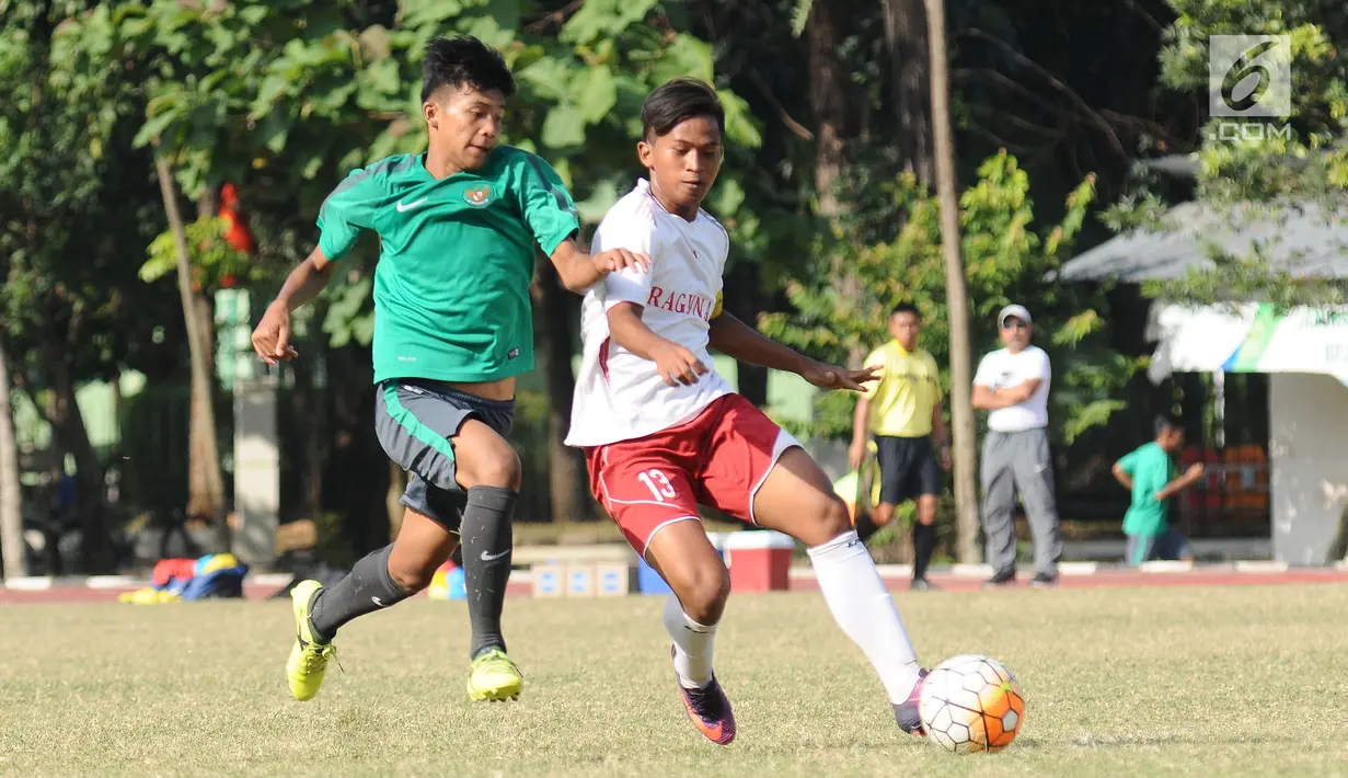 Pemain Timnas Indonesia U-16 (kaus hijau) berebut bola dengan pemain Asian School U-18 di Lapangan Atang Sutresna, Jakarta, Jumat (25/8). Uji tanding ini persiapan jelang kualifikasi Piala Asia U-16, September mendatang. (Liputan6.com/Helmi Fithriansyah)