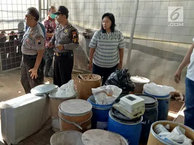 Polisi saat menyita bahan baku pembuatan pil PCC di Jalan Raya Batu Raden, Pabuaran, Purwokerto (19/9). Pabrik ini menghasilkan pil PCC ratusan ribu dalam satu malam. (Liputan6.com/Pool/Frans Fadlan)