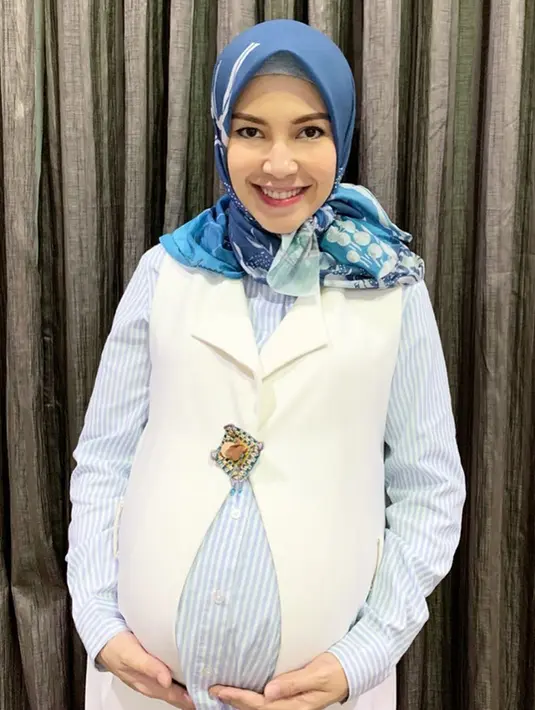 Ratna Galih tersenyum bahagia saat sedang memegang perutnya yang tengah hamil besar. Style busana Ratna juga terlihat begitu menawan. Dengan memadukan warna biru dan putih, terlihat begitu pas di tubuh Ratna. (Liputan6.com/IG/@ratnagalih)