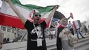 Seorang fans mengibarkan bendera Iran saat merayakan kemenangan atas Maroko pada laga Piala Dunia di Saint Petersburg, Rusia, Jumat, (15/6/2018). Iran Menang 1-0 atas Maroko. (AP/Dmitri Lovetsky)