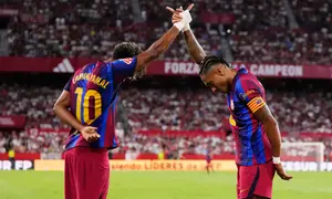 Raphinha dari Barcelona, ​​kanan, merayakan bersama Lamine Yamal setelah mencetak gol kedua timnya dalam pertandingan La Liga Spanyol antara Sevilla dan Barcelona di Seville, Spanyol, Minggu (20-9-2026) dini hari WIB. (AP Photo/Jose Breton)