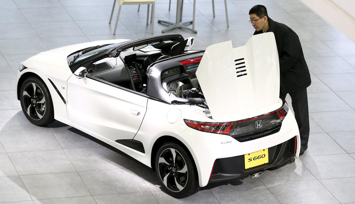 Pria melihat mobil Honda S660 di markas besar Honda Motor Co di Tokyo, Jepang, (24/2). Setelah hampir setahun pengerjaan, CEO Honda Motor Co Takahiro Hachigo berencana memperkenalkan mobil Honda S660 ke Publik. (REUTERS/Thomas Peter)