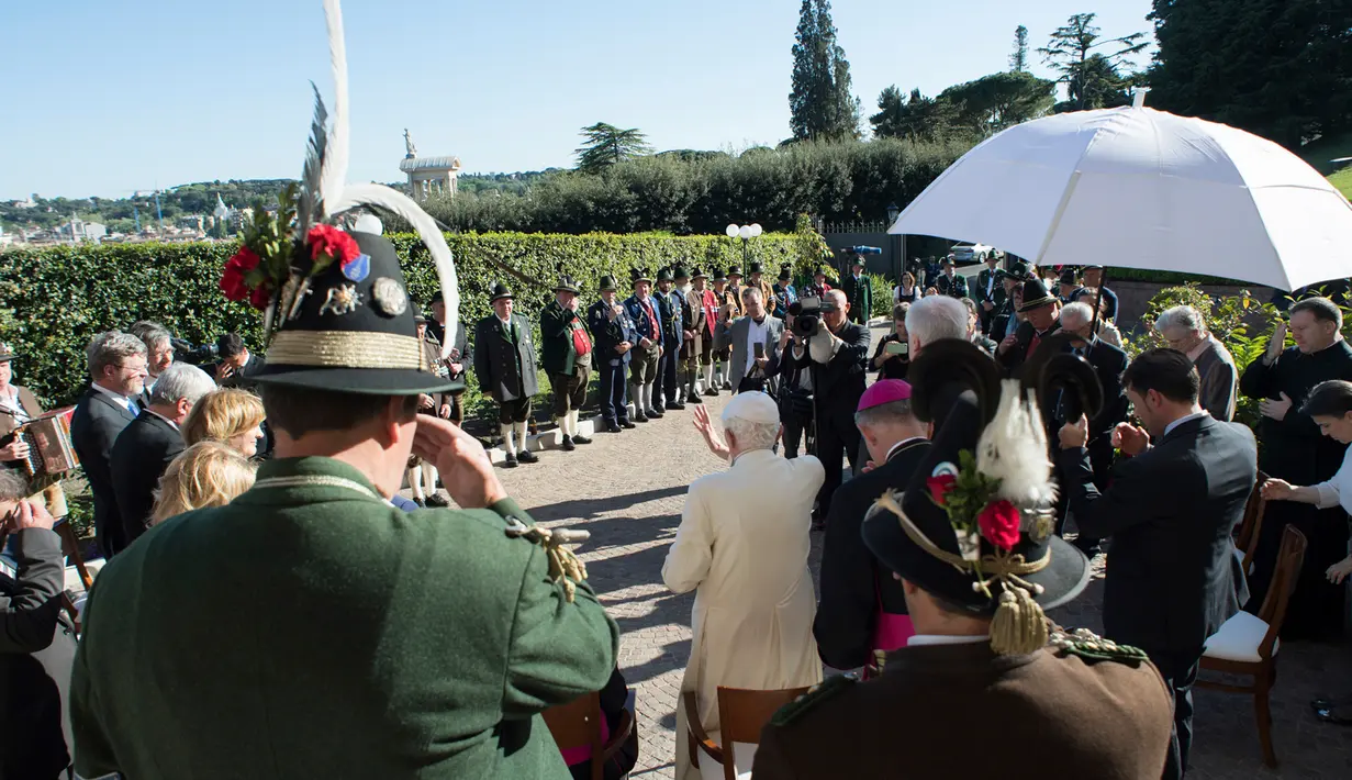 Paus Emeritus Benediktus XVI menyapa para delegasi dari Bavaria saat ulang tahunnya yang ke-90 di Vatikan (17/4). Ia melayani sebagai Paus ke-265 Gereja Katolik Roma sejak 19 April 2005 hingga 28 Februari 2013. (L'Osservatore Romano/Pool Photo via AP)