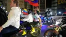 Pembebasan ini merupakan bagian dari percepatan kebijakan yang diumumkan pemerintah, menyusul perubahan besar dalam dinamika politik Venezuela. Tampak dalam foto, pemimpin oposisi María Oropeza dan Juan Pablo Guanipa mengendarai sepeda motor melalui Caracas, Venezuela, setelah dibebaskan dari tahanan, Minggu 8 Februari 2026. (AP Photo/Ariana Cubillos)