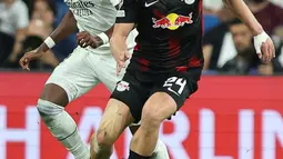 Bek Real Madrid David Alaba (kiri) berebut bola dengan pemain tengah Red Bull Leipzig Xaver Schlager pada matchday 2 Liga Champions berlangsung di Santiago Bernabeu, Kamis (15/9/2022) dini hari WIB. Real Madrid menang susah payah 2-0 kala menjamu RB Leipzig. (Photo by Thomas COEX / AFP)