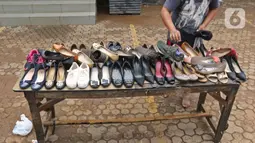 Pegawai menjemur sepatu di salah satu bank kawasan Kemang Raya, Jakarta, Kamis (2/1/2020). Para pegawai mulai membersihkan ruangan yang terendam air pascabanjir yang melanda Kemang Raya. (Liputan6.com/Herman Zakharia)