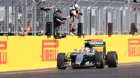 Pebalap Mercedes, Lewis Hamilton, saat finis pertama dalam balapan F1 GP Hungaria di Sirkuit Hungaroring, Budapest, Minggu (24/7/2016). (AFP/Ferenc Isza)