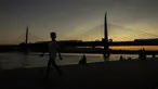 Seorang wanita berjalan di dekat the Golden Horn atau tanduk emas di Istanbul (26/7/2019). Tanduk Emas merupakan jalur air perkotaan utama dan pintu masuk utama Bosphorus di Istanbul, Turki. (AP Photo/Emrah Gurel)