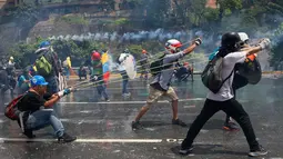 Demonstran anti-Presiden Venezeula Nicholas Maduro bersiap melemparkan sebotol tinja dengan ketapel raksasa ke arah pasukan keamanan di Caracas, 10 Mei 2017. Senjata tinja itu dinamakan dengan sebutan “koktail Poopootov” (AP Photo/Fernando Llano)