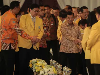 Wakil Presiden Jusuf Kalla (tengah) didampingi Ketum Golkar Airlangga Hartarto saat menghadiri penutupan Munaslub Golkar di Jakarta, Rabu (20/12). Jusuf Kalla mengenakan batik berwarna emas saat menghadiri acara tersebut. (Liputan6.com/Faizal Fanani)