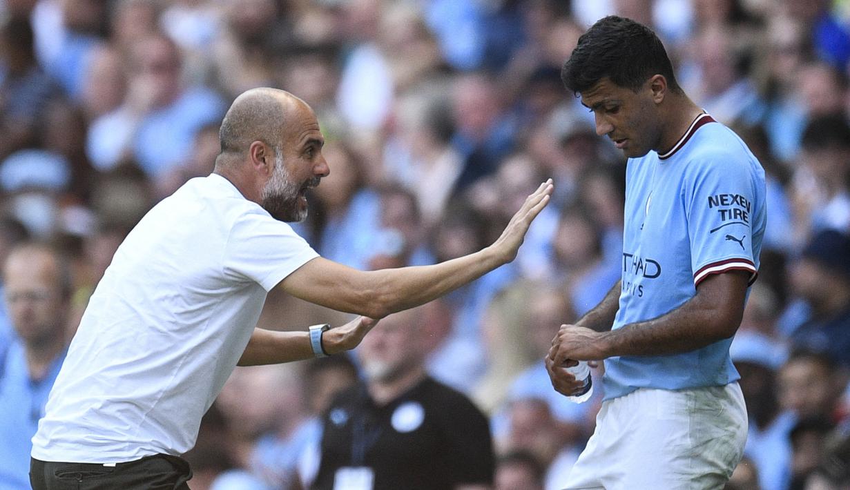 Pelatih Manchester City, Pep Guardiola (kiri) berbicara kepada Rodri dalam pertandingan lanjutan Liga Inggris 2022/2023 melawan Bournemouth di Eitihad Stadium, Sabtu (13/8/2022). Rodri pastinya ingin terus bermain di level tertinggi dan tidak ingin turun kasta jikalau Manchester City terbukti bersalah. Mengingat dirinya yang masih berusia 26 tahun dan salah satu pemain terbaik di Liga Inggris. (AFP/Oli Scarff)