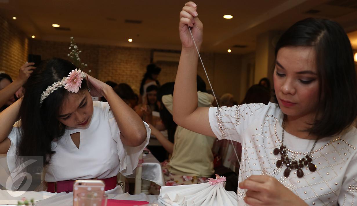 Bloggres mengikuti pembuatan bandon dari mutiara saat women's talk launching ovale bedak dingin, Jakarta, Jumat (27/11). Ovale meluncurkan produk terbarunya yakni Ovale Bedak Dingin Whitening dengan Ekstrak Mutiara. (Liputan6.com/Herman Zakharia) 