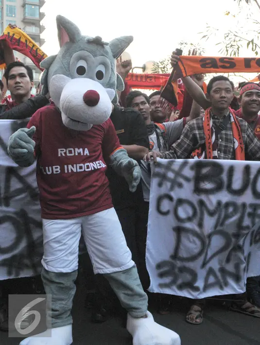Srigala adalah ilustrasi dari mitos Romulus dan Remus, yang merupakan cerita terbentuknya kota Roma dikenakan oleh penggemarnya saat menyambut kedatangan skuad AS Roma di Hotel Shangri La, Jakarta, Jumat (24/7/2015). (Liputan6.com/Herman Zakharia)