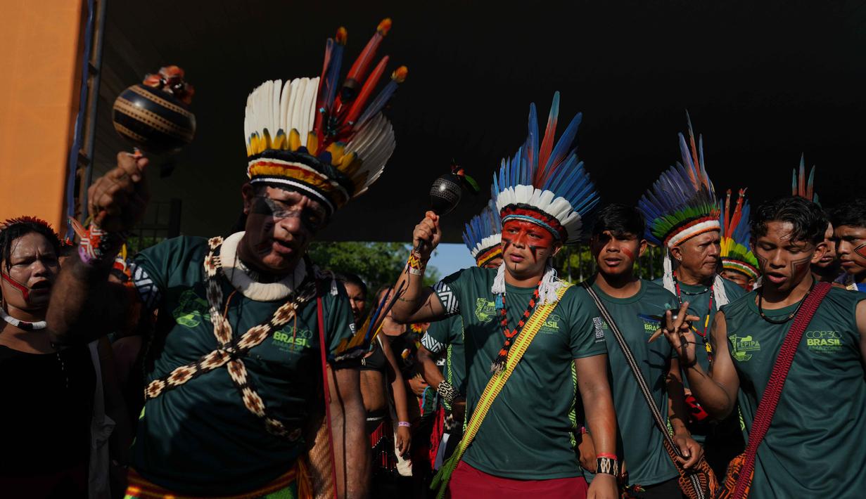 Secara keseluruhan, unjuk rasa masyarakat adat ini menyoroti kerentanan terhadap krisis iklim dan proyek pembangunan. Tampak dalam foto, suku-suku asli melakukan demonstrasi selama protes di tengah-tengah perhelatan Konferensi Tingkat Tinggi Perubahan Iklim PBB (COP30), di Belem, Brasil, Senin 17 November 2025. (AP Photo/Andre Penner)