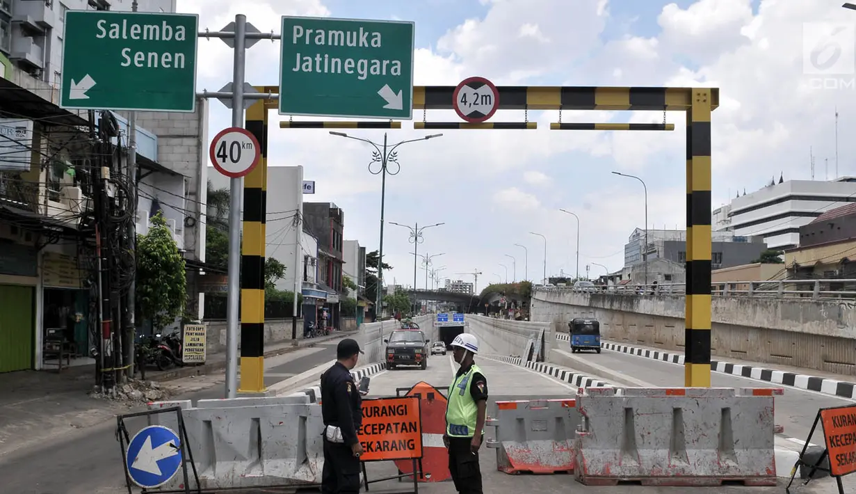 Petugas keamanan berjaga di depan pintu masuk Underpass Matraman, Jakarta, Minggu (1/4). Uji coba Underpass Matraman yang rencananya dimulai pada hari ini batal dilakukan karena masih dalam pembahasan rekayasa lalu lintas. (Merdeka.com/Iqbal S Nugroho)