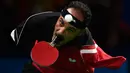 Ekspresi atlet asal Mesir, Ibrahim Hamadtou saat hendak memukul bola menggunakan mulutnya ke arah atlet asal Jerman, Thoma Rau pada cabang tenis meja tunggal putra di ajang Paralimpiade 2016, Rio de Janeiro, 9 September 2016. (CHRISTOPHE SIMON/AFP)