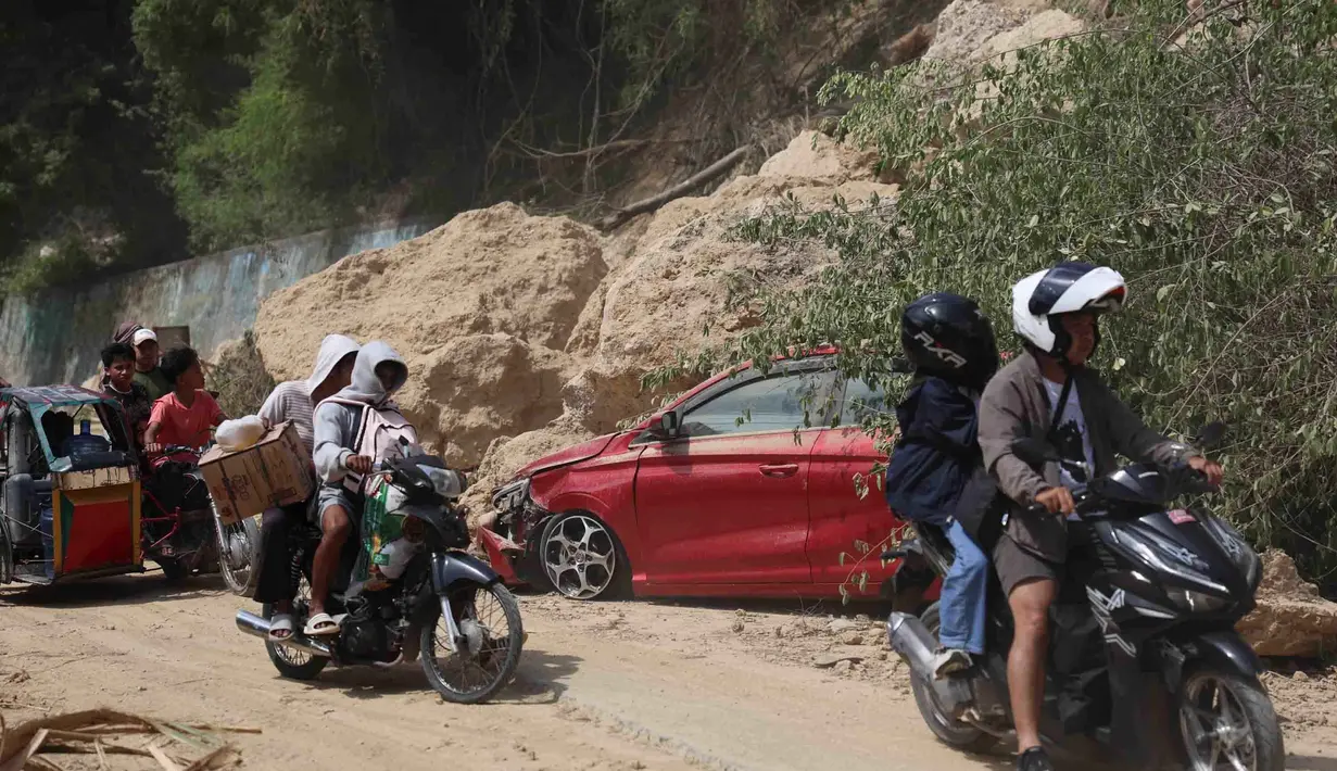 Para pengendara motor melewati lokasi tanah longsor akibat gempa bumi, Provinsi Sarangani, Filipina, Rabu 10 Juni 2026. (AP Photo/Basilio Sepe)
