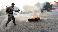 Seorang anggota polisi memeragakan teknik pemadaman api menggunakan alat pemadam ringan dalam peragaan pengamanan pemilu yang digelar di Mako Brimob Kelapa Dua (Liputan6.com/ Helmi Fithriansyah)