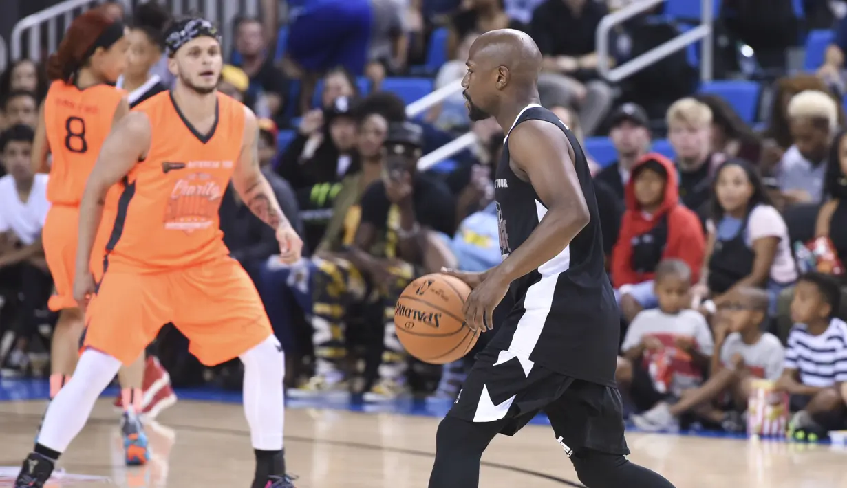 Petinju asal AS, Floyd Mayweather mendribble bola saat bertanding pada acara Monster Energy Outbreak Presents $50K Charity Challenge Celebrity Basketball Game di UCLA's Pauley Pavilion di Westwood, California (17/7). (AFP Photo/Vivien Killilea)