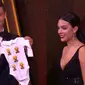 Cristiano Ronaldo dan kekasihnya, Georgina Rodriguez, memamerkan baju bayi yang diberikan pihak penyelenggara Ballon d'Or 2017. (Marca)