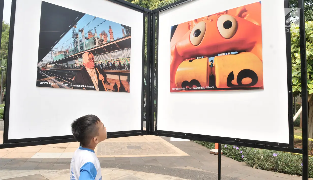 Siswa SD Negeri Menteng 01 mengamati karya foto yang dipamerkan dalam pameran fotografi Rekam Jakarta di Taman Menteng, Kamis (29/8/2019). Kegiatan tersebut dalam rangka edukasi bagi siswa mengenal profesi foto jurnalistik. (merdeka.com/Iqbal S Nugroho)