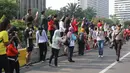 Warga yang tengah mengikuti Car Free Day (CFD) mengabadikan gambar Parade Asian Games 2018 2018 di Jalan Thamrin, Jakarta, Minggu (13/5). Tak merasa terganggu, mereka justru ikut antusias menyaksikan parade itu. (Liputan6.com/Arya Manggala)
