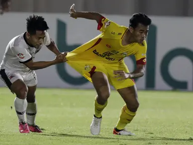 Gelandang Madura United, Andik Vermansah menarik baju bek Bhayangkara FC, Nurhidayat, pada laga Liga 1 2019 di Stadion Madya, Jakarta, Senin (5/8). (Bola.com/M iqbal Ichsan)