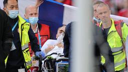 Menurut laporan Kicker, Tim Dokter kabarnya mengangkat jempol ke atas sebelum Eriksen dibawa keluar. Tanda jempol ke atas ini mengindikasikan kondisi Eriksen sudah baikan, dan itu sudah disambut sorakan penonton diatas lapangan. (Foto: AFP/Pool/Friedemann Vogel)