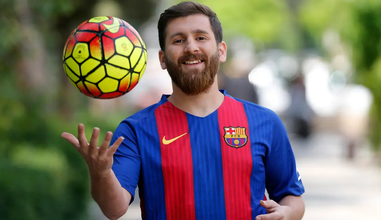 Pemuda asal Iran, Reza Parastesh (25) berpose di sebuah jalan di Teheran, Senin (8/5). Nama Reza Parastesh akhir-akhir ini menjadi perbincangan karena memiliki paras serupa megabintang Barcelona Lionel Messi. (AFP PHOTO/ATTA KENARE)