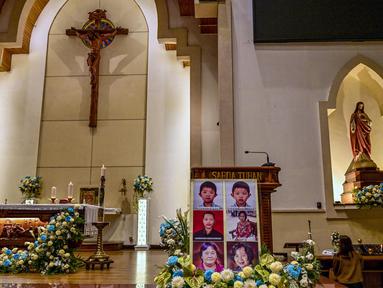Potret para korban bom bunuh diri terlihat saat orang-orang menghadiri upacara peringatan di Gereja Katolik Santa Maria, Surabaya, Jawa Timur, pada 13 Mei 2025. (Juni KRISWANTO/AFP)