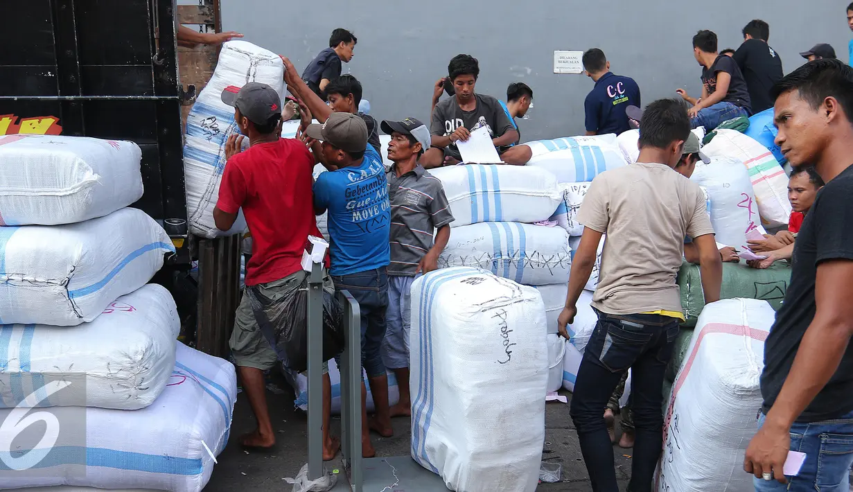 Pekerja memasukkan karung ke dalam mobil untuk didistribusikan ke seluruh daerah di Indonesia, Jakarta, Jumat (27/5). Melonjaknya permintaan pakaian jelang puasa menjadi berkah bagi para pedagang. (Liputan6.com/Angga Yuniar)