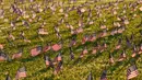 Aktivis dari COVID Memorial Project meletakkan ribuan bendera Amerika berukuran kecil di di halaman National Mall di Washington, Selasa (22/9/2020). Ribuan bendera itu menandai 200 ribu nyawa yang hilang akibat virus corona Covid-19 di Amerika Serikat. (AP Photo/J. Scott Applewhite)