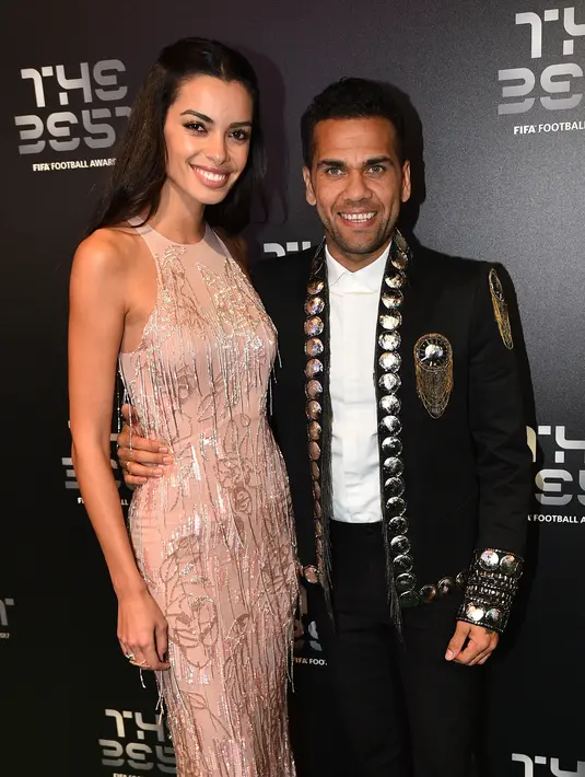 Penyerang Paris Saint-Germain, Dani Alves dan istrinya Joana Sanz berpose setibanya di The Best FIFA Football Awards, London, Senin (23/10). Sejumlah penghargaan diberikan FIFA kepada para pelaku penting di dalam dan luar lapangan hijau. (Glyn KIRK/AFP)