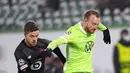 Pemain Lille Gabriel Gudmundsson (kiri) berebut bola dengan pemain Wolfsburg Maximilian Arnold pada pertandingan sepak bola Grup G Liga Champions di Wolfsburg, Jerman, 8 Desember 2021. Lille menang 3-1. (AP Photo/Martin Meissner)