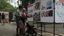 Melalui pameran ini, penyelenggara berupaya memberikan informasi mengenai kebijakan strategis pemerintah secara komprehensif dan mudah diakses masyarakat. Tampak dalam foto, pengunjung menyaksikan karya foto jurnalistik dalam pameran Haluan Merah Putih Roadshow yang digelar di Selasar Kantin Taman Margasatwa Ragunan, Jakarta Selatan, Rabu (24/12/2025). (merdeka.com/magang/Rendi Saputra)
