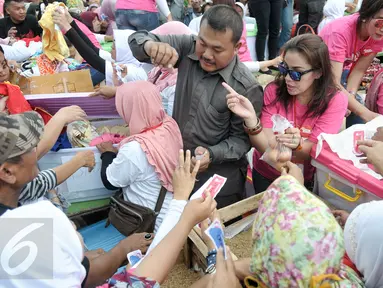 Sejumlah warga berdesakan membeli bahan pokok di pasar rakyat kawasan Cilandak, Jakarta Selatan, Senin (19/12). Pasar rakyat tersebut diadakan relawan pendukung cagub dan cawagub DKI Jakarta Anies Baswedan dan Sandiga Uno. (Liputan6.com/Yoppy Renato)