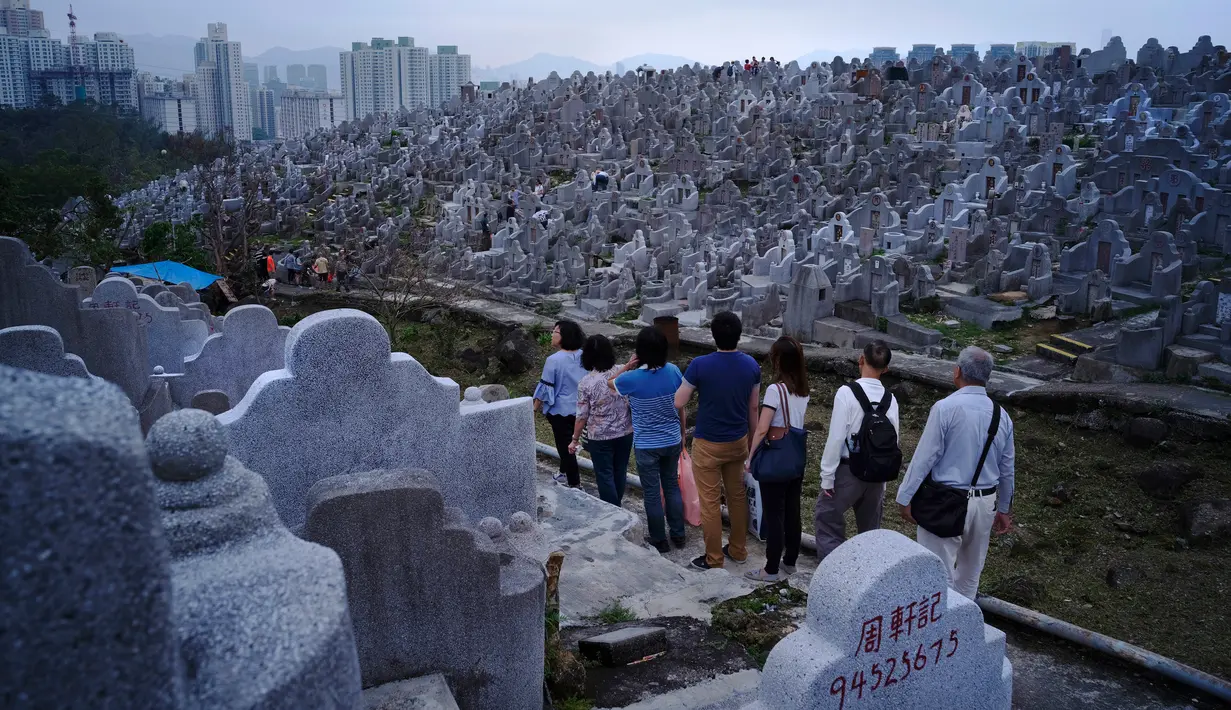 Orang-orang mengunjungi makam kerabat saat Festival Chung Yeung atau juga dikenal Tomb Sweeping Day di Hong Kong, 17 Oktober 2018. Pada saat festival, ribuan warga Hong Kong memberi penghormatan kepada leluhur mereka yang meninggal.  (AP/Vincent Yu)