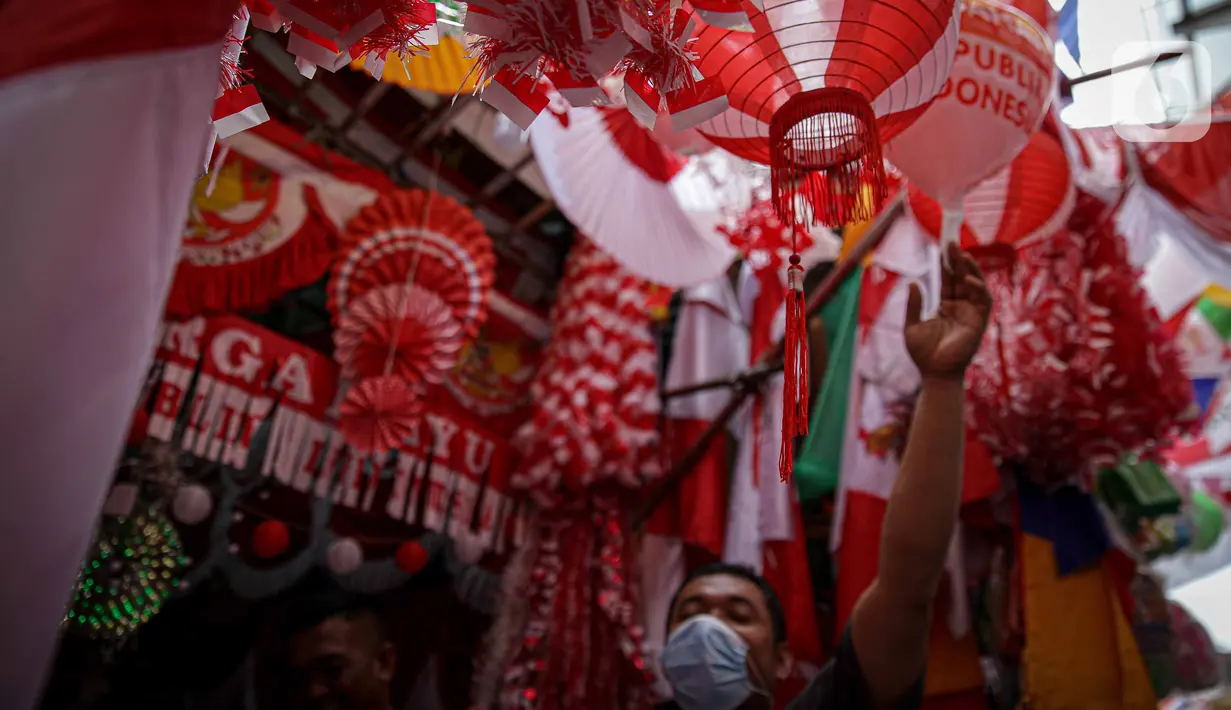 Pedagang menunggu pembeli pernak pernik HUT Republik Indonesia di Pasar Jatinegara, Jakarta, Selasa (10/8/2021). Dua tahun pandemi Covid-19 berjalan, penjual pernak pernik hingga bendera merah putih  turun rata-rata 50-70 persen. (Liputan6.com/Faizal Fanani)