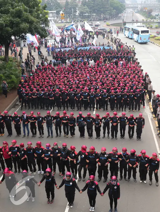 Ribuan buruh melakukan aksi jalan kaki menuju Istana Merdeka, Jakarta, Sabtu (6/2/2016). Dalam aksi tersebut mereka meminta agar tidak terjadi PHK secara besar-besaran. (Liputan6.com/Angga Yuniar)